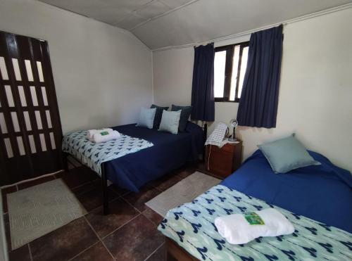 twee bedden in een kamer met blauw en wit bij Cabañitas Remanso, baño privado in Isla de Maipo