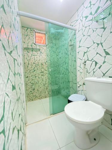 a bathroom with a toilet and a glass shower at FLAT BAÍA DO SANCHO in Fernando de Noronha