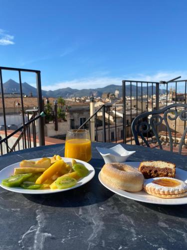 een tafel met twee borden eten en een glas sinaasappelsap bij Dimora Sinibaldi in Palermo