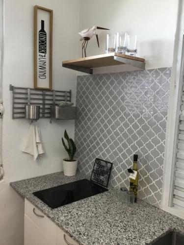a kitchen counter with a sink in a room at One bedroom Apt 30 steps from prime beach generator parking included in San Juan
