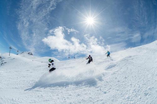 a group of people skiing down a snow covered slope at ROYAL SUITE TOTTO'NETTA 504 in Passo del Tonale