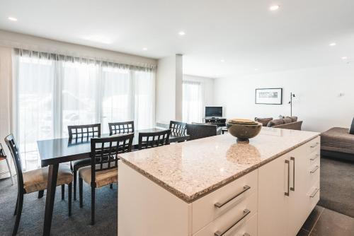 a kitchen and living room with a table and chairs at Blue Peaks Apartments in Queenstown
