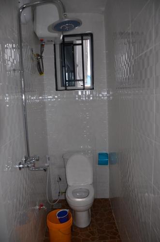 baño pequeño con aseo y ventana en Lunguya Annex Lodge, en Dar es Salaam