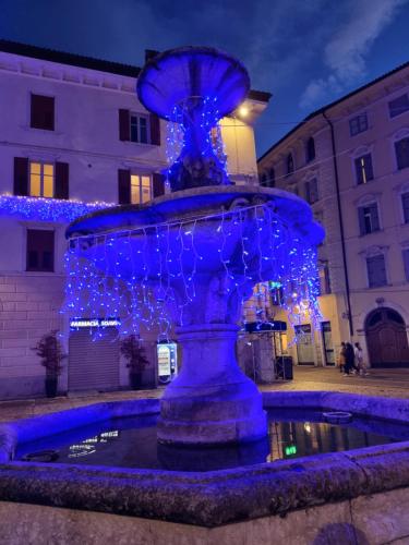 a blue fountain with christmas lights on it at Apartments via Roma in Rovereto