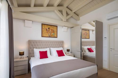 sypialnia z dużym białym łóżkiem z czerwonymi poduszkami w obiekcie Villa Blanche by ILC (Istria Luxury Collection) w mieście Brtonigla