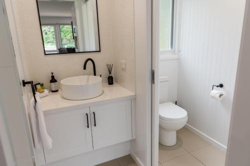 a white bathroom with a sink and a toilet at McMillans of Metung Coastal Resort in Metung