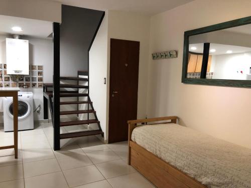 a bedroom with a bed and a mirror and a staircase at Pastoriza Apartamento Amplio 2 Ambientes in Ushuaia