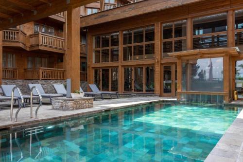 an indoor pool with chairs and a building at Pirin Golf Hotel Private Studios in Razlog