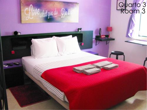 Un dormitorio con una cama grande con una manta roja. en Alojamento Tiago & Jorge Guesthouse, en Nazaré
