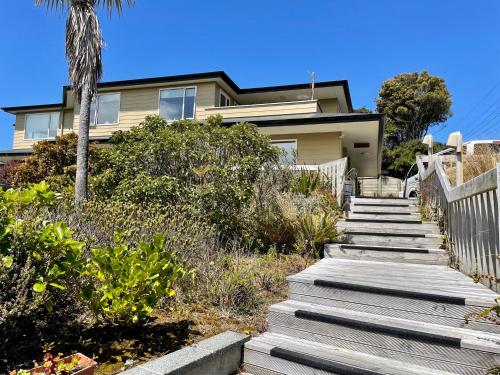 a house with stairs in front of it with a palm tree at The Bay Motel in Half-moon Bay
