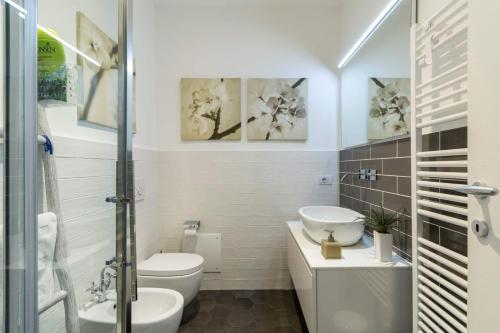 a white bathroom with a toilet and a sink at Royal Cadenabbia in Griante Cadenabbia
