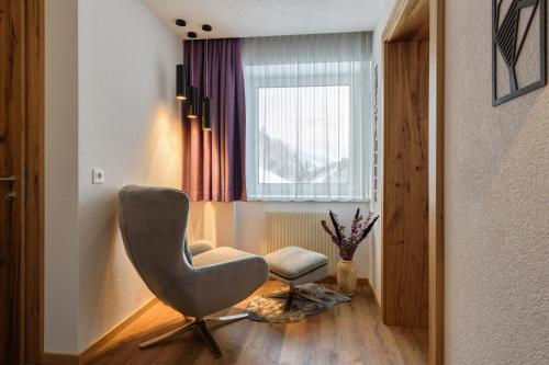 a living room with a chair and a window at Augl‘s Hof in Ischgl