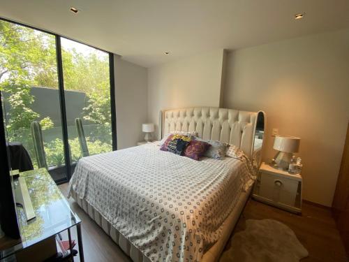 a bedroom with a bed and a large window at Departamento para Ejecutivos en el Sur de la CDMX in Mexico City