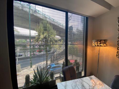 a room with a large window with a view of a city at Departamento para Ejecutivos en el Sur de la CDMX in Mexico City