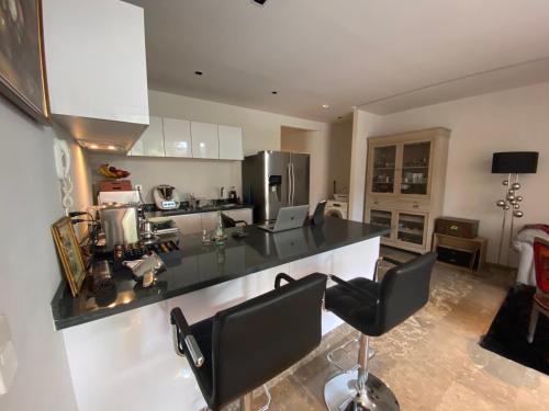 a kitchen with a counter and two bar chairs at Departamento para Ejecutivos en el Sur de la CDMX in Mexico City