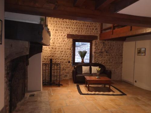 a living room with a couch and a fireplace at Maison Pérouges spa in Pérouges