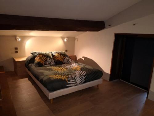 Maison Pérouges spa في بيروج: غرفة نوم مع سرير ووسائد حمار الوحشي عليه