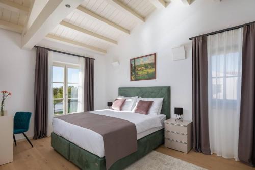 Un dormitorio con una cama grande y una ventana en Villa Divine by ILC (Istria Luxury Collection) en Brtonigla