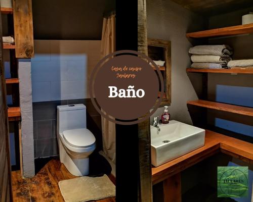 a bathroom with a white toilet and a sink at Casa de campo Jaulares in Alaska