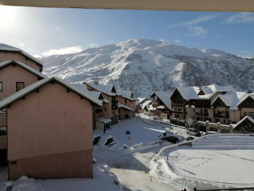 une montagne recouverte de neige avec des bâtiments et des toits recouverts de neige dans l'établissement APPARTEMENT VALMEINIER 1800 / RESIDENCE L'OURS BLANC, à Valmeinier