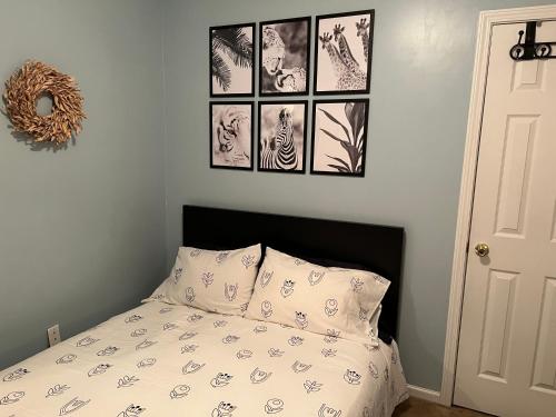 a bedroom with a bed with four pictures on the wall at BlaBla Lounge in Charlotte