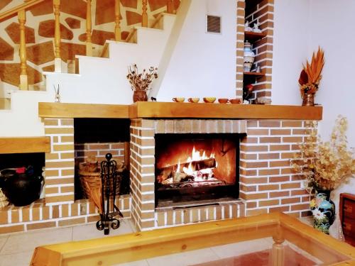 Una chimenea de ladrillo con fuego. en Casa do Pombar en Valdeorras, 