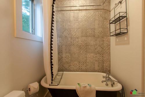 La salle de bains est pourvue d'une baignoire et d'une douche. dans l'établissement Unique Tremblant view -fancy fully equipped apartment, à Mont-Tremblant