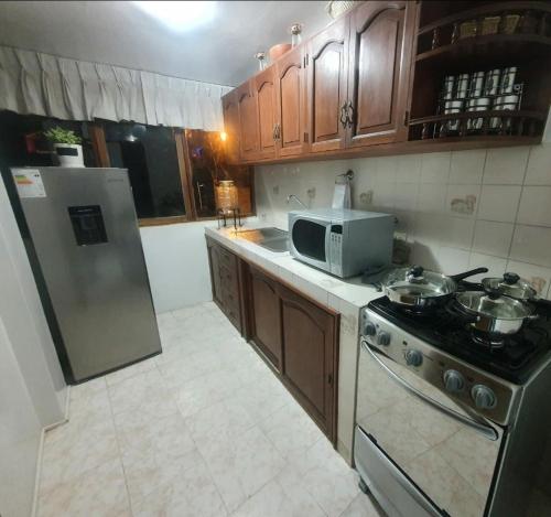 a kitchen with a stove and a microwave at Depa Céntrico, cerca a todo! in Cajamarca