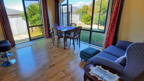 パラパラウム・ビーチにあるQuiet homestay, private room with own bathroomのテーブルと椅子と窓のあるリビングルーム