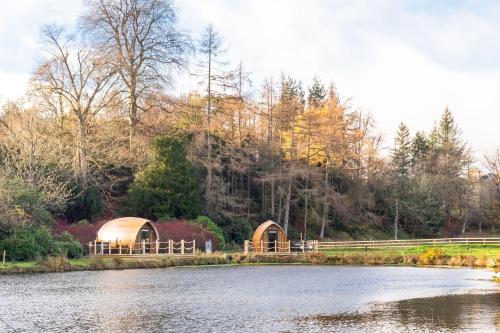 a couple of domes next to a body of water at The Secret Hideaway in Penicuik