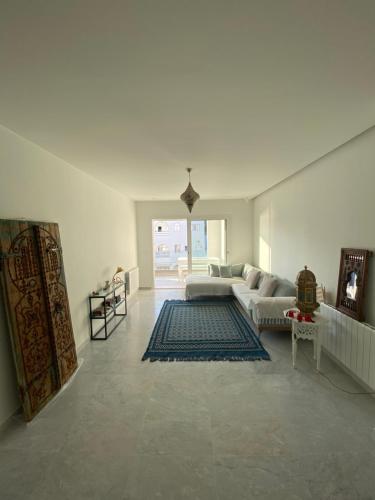 a white living room with a couch and a rug at Dar Sheherazade in Hammamet