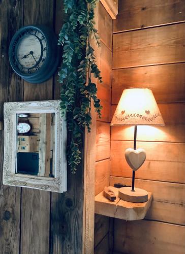 a lamp in a room with a mirror and a clock at Charmant Mazot in Saint-Gervais-les-Bains