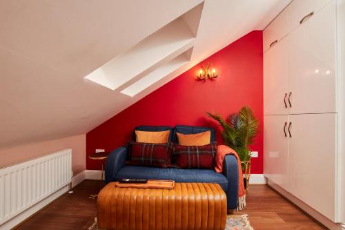 a living room with a blue couch and a red wall at The Exquisite Gem of Newcastle - Sleeps 2 in Newcastle upon Tyne