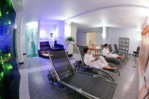 two people sitting in chairs in a room at Hotel Rischli in Sörenberg