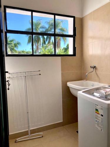 a bathroom with a window and a sink and a tub at Paseo Camila in Goya