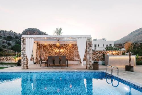 a pavilion with a table and chairs next to a pool at Lindos Villa Aqua Euphoria ex Natura in Líndos