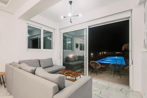 a living room with a couch and a table at Lindos Villa Aqua Euphoria ex Natura in Líndos