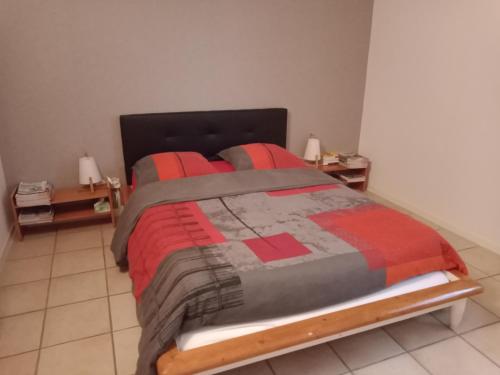 - une chambre avec un lit doté d'une couette rouge et grise dans l'établissement Superbe T3 de 85 mètres Carrés, à Toulouse