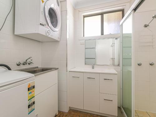 uma cozinha branca com um lavatório e um micro-ondas em Como Unit 6 em Gold Coast