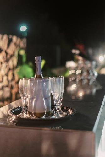 a table with glasses and a bottle on a tray at Lindos Villa Aqua Euphoria ex Natura in Líndos
