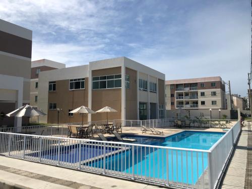 伊列乌斯Apê Ilha Graciosa, Praia dos Milionários Ilhéus-Ba的建筑物前有椅子和遮阳伞的游泳池