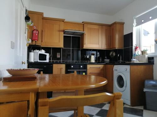 une cuisine avec une table en bois et une salle à manger dans l'établissement Castle Hill Cottage & Paddlers Retreat, à Ballywalter