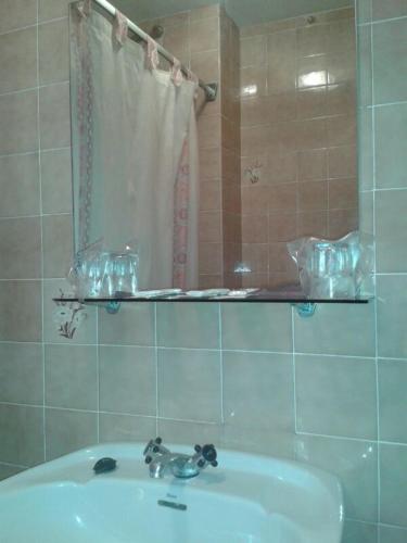 a bathroom with a sink and a mirror at Hotel Los Nogales in Noja