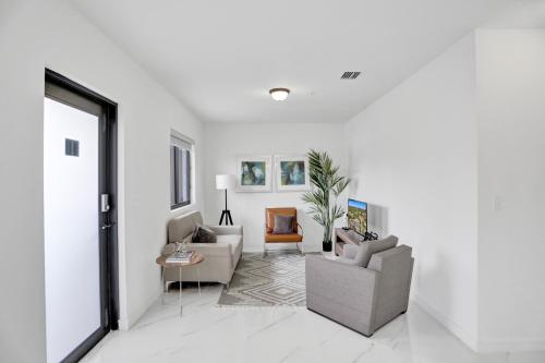a living room with white walls and white floors at Renzzi Wynwood Apartments in Miami