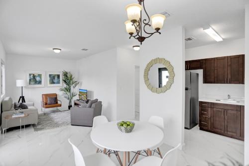 a living room with a white table and a kitchen at Renzzi Wynwood Apartments in Miami