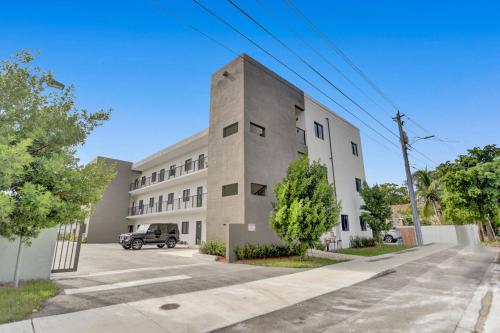 a large concrete building with a car parked in front at Renzzi Wynwood Apartments in Miami