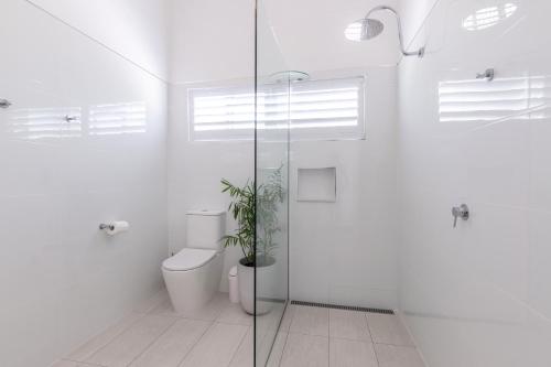 a bathroom with a toilet and a glass shower at Debbie's Place in Rainbow Beach