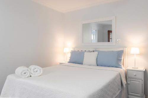 a white bedroom with a large bed with towels on it at Debbie's Place in Rainbow Beach