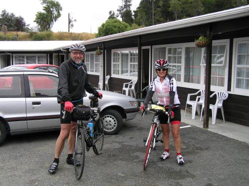 a man and a woman on bikes in a parking lot at Coachman Motel in Taihape