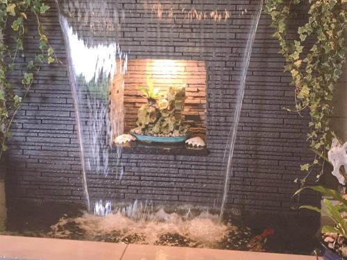 a water feature in a brick wall with a fountain at Room Biotop YOMITAN in Yomitan